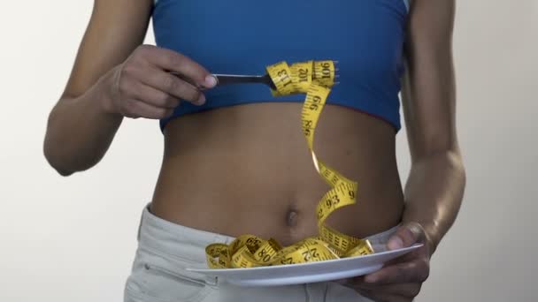 Smal blandad ras tjej slingrande tapeline på gaffeln, friska bantning och viktminskning — Stockvideo