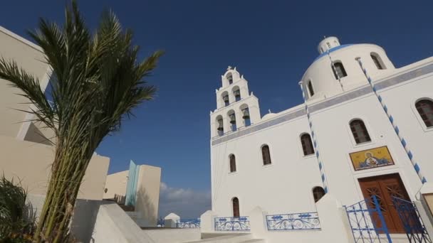 Santorini, Grecja - około lipca 2014: Zwiedzanie na wyspie. Kościół chrześcijański w kolorze białym przeciw błękitne niebo na słoneczny dzień, mozaiki na ścianach — Wideo stockowe