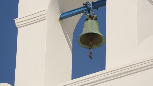 Campana vieja oxidada que entrega en arco blanco contra el cielo azul claro en el día soleado del verano — Vídeos de Stock