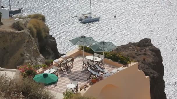 Cliff met lunch gebied op de top, zee glittering hieronder met afgemeerd boten, vakantie — Stockvideo