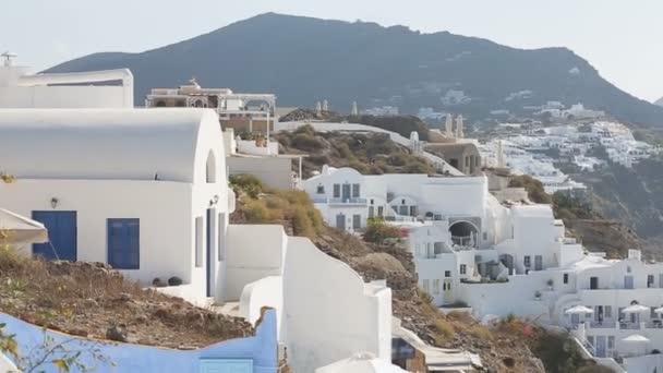 Гірський острів з білими будинками, розкиданими по схилах, засвічене море з човнами — стокове відео