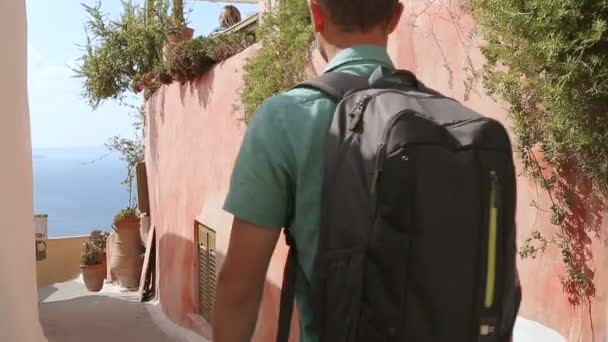 Man lopen door smalle straatjes op zonnige dag op Santorini eiland Griekenland toerisme — Stockvideo