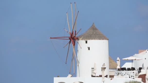 Moinho de vento decorativo em pé contra o céu azul em Santorini, Grécia, aluguel de casa — Vídeo de Stock