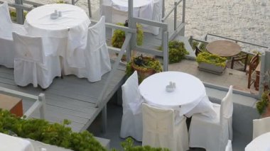 Yemek masaları terasta deniz, sahil restoranında yemek üzerinde duran başvurmak