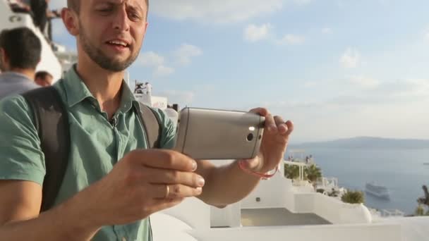 Turist tar video av omgivningen, att göra roliga ansikten medan du tittar på skärmen — Stockvideo