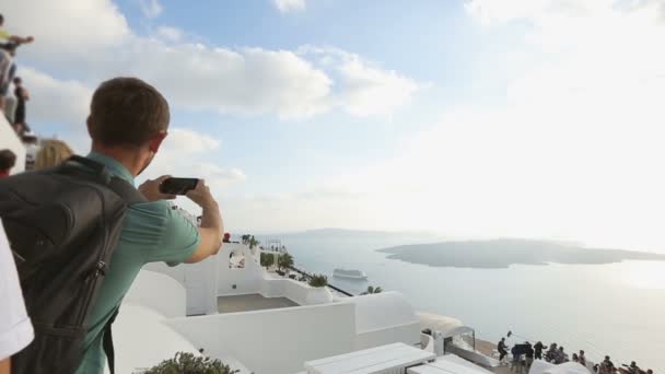 Mochilero haciendo video de la actuación callejera en Santorini, atracción popular — Vídeo de stock