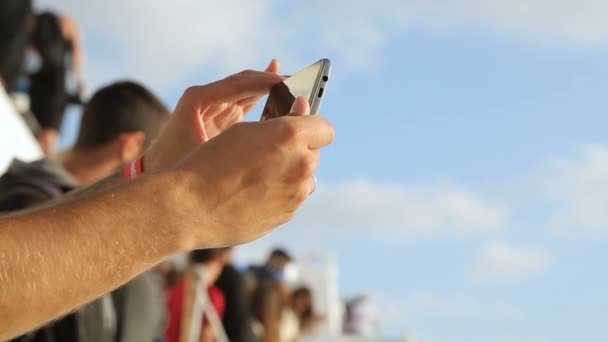 Hombre sosteniendo el teléfono inteligente en las manos, comprobando el vídeo grabado antes, famoso festival — Vídeos de Stock