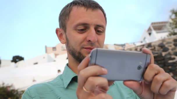 Young male holding cellphone, watching video with surprised expression, emotions — Stock Video