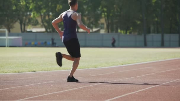 Tipo corriendo en el estadio, los músculos de la pierna de entrenamiento y el corazón, el espíritu sano y el cuerpo — Vídeos de Stock