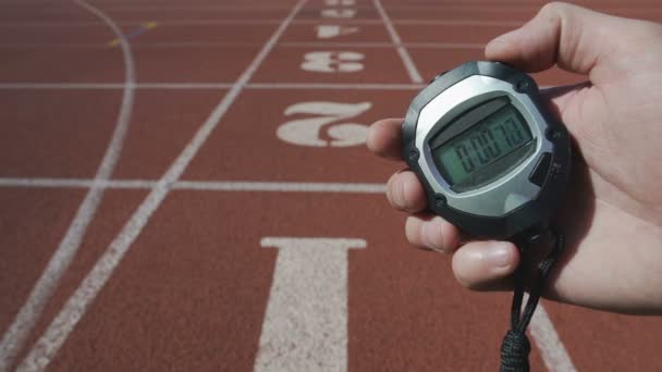 Mano masculina encendiendo cronómetro para registrar el tiempo durante la competición deportiva, fecha límite — Vídeos de Stock