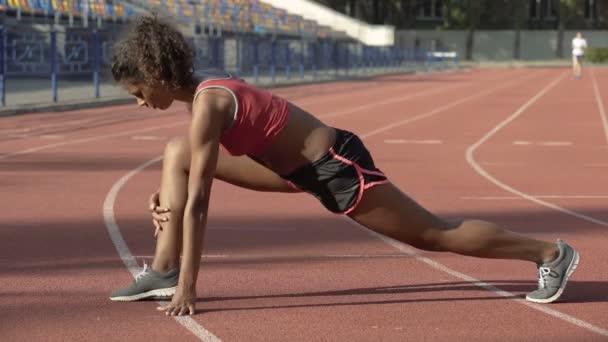 Biracial dama estirando y calentando sus músculos de la pierna antes de empezar a correr — Vídeos de Stock