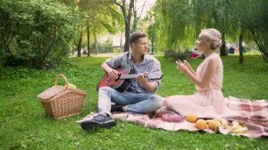 Neşeli sevinçle dans ve şarkı gitar, çalmak onun erkek arkadaşı bir kızla