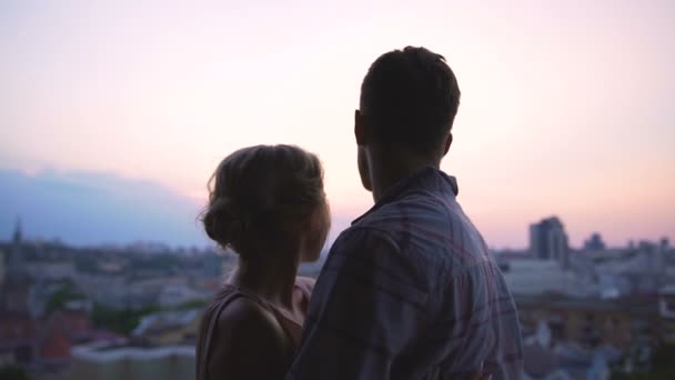 Recién casados de pie en el techo de un edificio alto, disfrutando de un amplio panorama de la ciudad — Vídeos de Stock