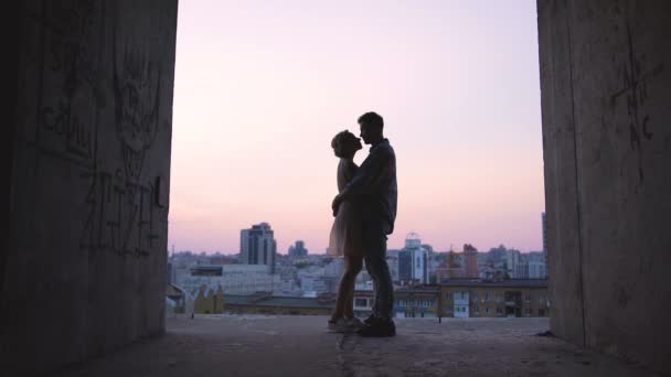 Sziluettek szerelmesek átölelve, háttérben a horizonton, romantikus naplemente — Stock videók