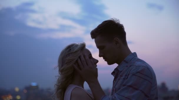 Молодая пара тайно встречается на крыше дома, грустно целуясь, скрываясь от всех. — стоковое видео