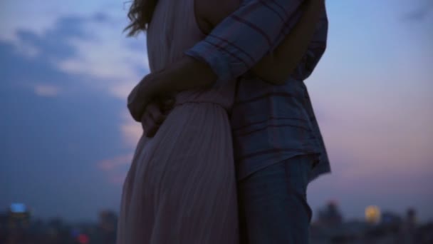 Αγάπη ζευγάρι αγκαλιάζονται και ψιθυρίζοντας τρυφερότητα στη στέγη στο σούρουπο — Αρχείο Βίντεο