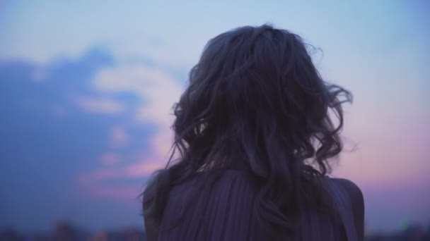 Самотня дівчина трясеться від холодного вітру, стоїть на краю даху, самотності — стокове відео