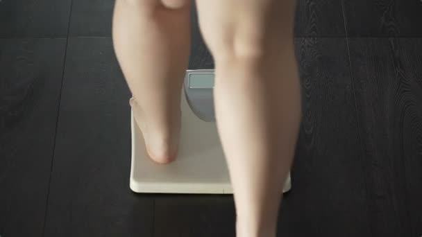 Woman stepping on scales, word obese appearing on screen, problems with weight — Stock Video