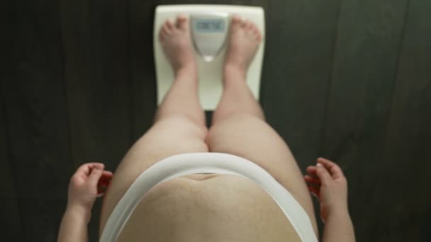 Kvinna som står på skalor med ordet feta på skärmen, misslyckades bantning, irriterad — Stockvideo