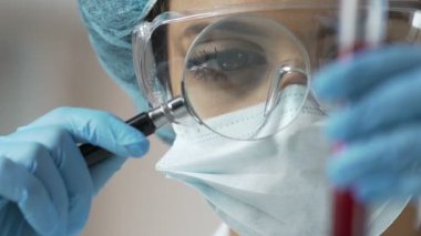 Kadın laboratuvar çalışan örnek inceleyerek yoğunluğu ve çökeller varlığı geri yüklemek için