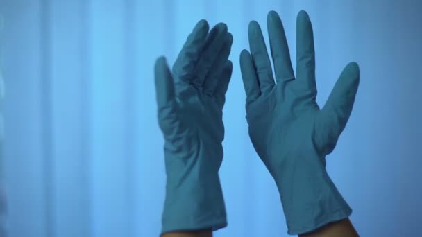Och tittar händer i latex gummihandskar, lyfter dem med irritation — Stockvideo