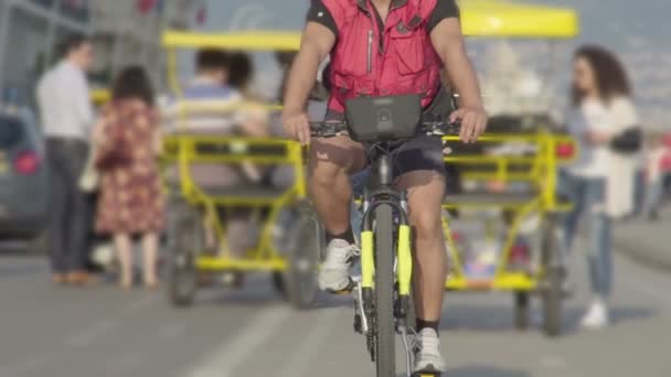 Uomo in bicicletta lungo la strada al rallentatore contro diversi carrelli risciò — Video Stock