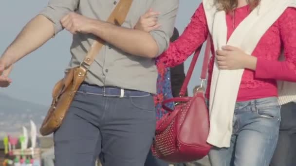 Couple walking down crowded street, holding hands and enjoying sunny day in city — Stock Video