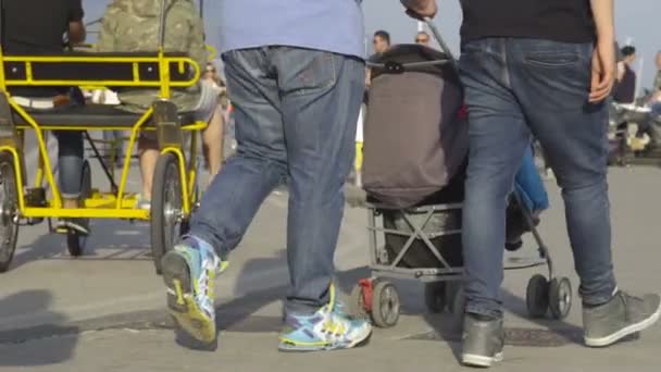 NAPLES, ITALY - CIRCA JULY 2014: People in the city. Couple of men pushing stroller while taking walk along waterfront on sunny day — Stock Video