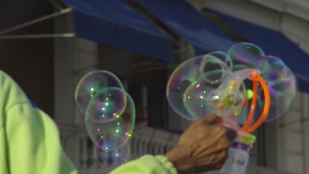 Уличный торговец, производящий много мыльных пузырей с игрушечной машиной, веселье, замедленное движение — стоковое видео