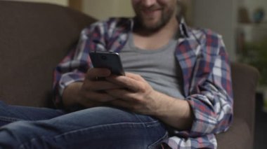 Erkek koltukta oturan ve cep telefonu gülümseyen, sosyalleşme tipik haber