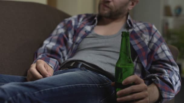 Depressieve man zit op de Bank drinken bier, buik, geldproblemen krabben — Stockvideo