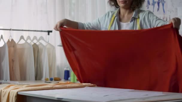 Pessoa criativa inspirada colocando na mesa pano vermelho e tamanho de medição, moda — Vídeo de Stock