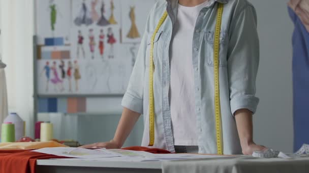 Kadın atelier sahibi takım elbise ve elbiseler Akşam tasarım çizimler seyir — Stok video