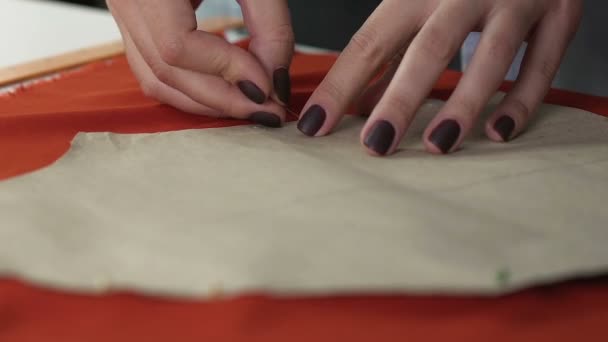 Dressmaker femme attachant le modèle par des épingles au tissu orange, processus de couture — Video