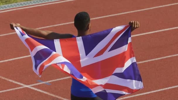 Emocionado campeón mostrando la bandera de Gran Bretaña a los partidarios, orgullo de la nación — Vídeo de stock