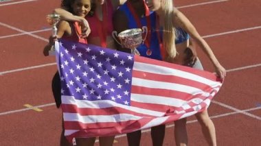ABD spor ekibi sarılma ve kutluyor zafer gülümseyen ülke bayrağı tutarak