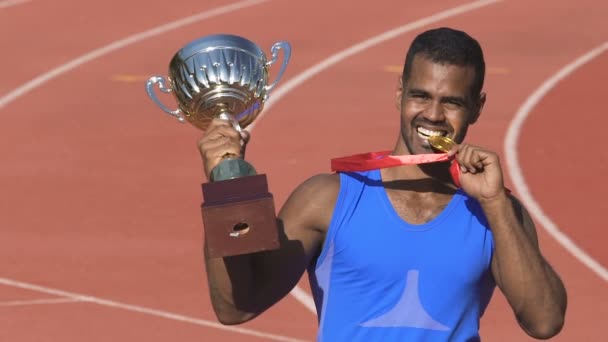 Esportista latino animado posando para paparazzi mostrando seus troféus, homem de sucesso — Vídeo de Stock