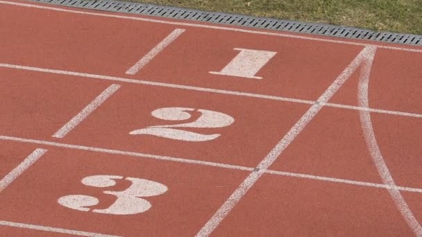 Close-up beeld van lege atletiekbaan met witte lijnen en nummers, stadion — Stockvideo