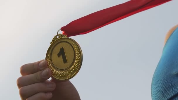 Joven corredora ganadora de la competición, chica sonriendo y besando medalla de oro — Vídeos de Stock