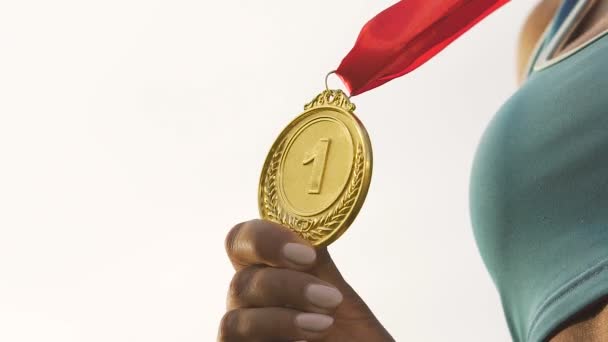 Athlète féminine naissante montrant la médaille d'or devant la caméra, le succès et la victoire — Video