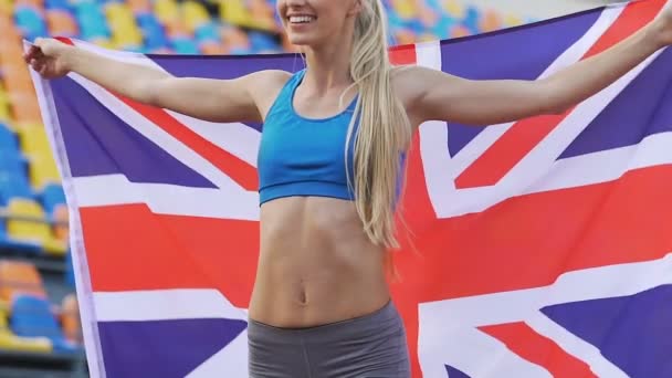 Radostné sportovkyně těší vítězství v soutěži sportovních a drží vlajku Velké Británie — Stock video