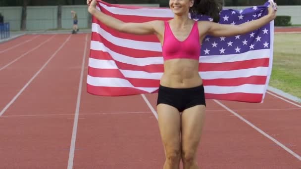 Deportista muy alegre disfrutando de la victoria deportiva y sosteniendo la bandera de EE.UU., slow-mo — Vídeo de stock