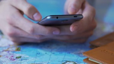 Holding smartphone, bilet rezervasyonu ve turistler app otelin closeup erkek eller