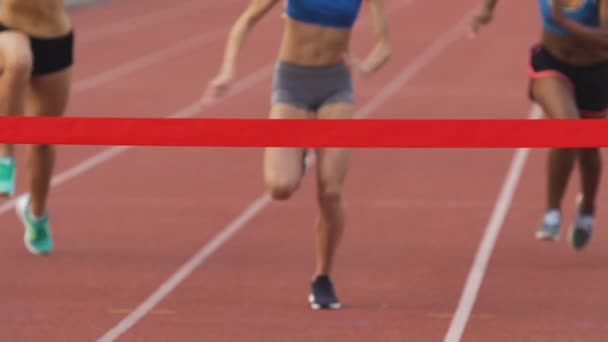 Jóvenes atletas corriendo en el estadio, cruzando la línea de meta en cámara lenta — Vídeo de stock