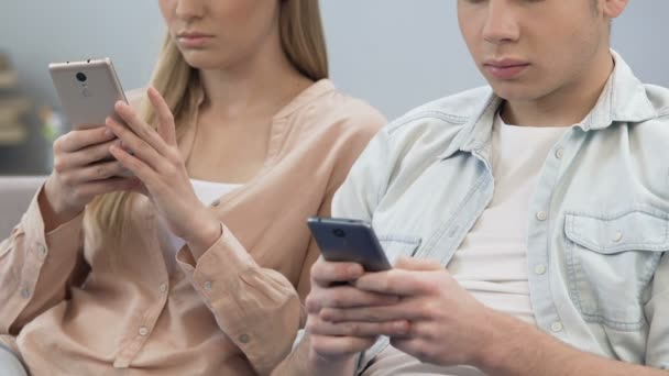 Tieners zittend op de Bank en het gebruik van smartphones tijdens de vergadering, online vrienden — Stockvideo