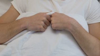 Genç erkek yatakta korkmuş, cinsel eğitim, eksikliği yatan rahatsız anlardan