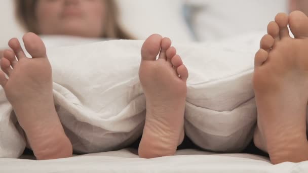 Ноги пары в удобной кровати, медовый месяц время сна, романтический отдых — стоковое видео