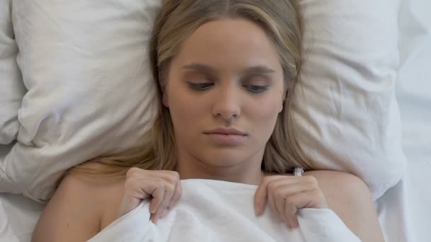 Όμορφη νεαρή γυναίκα στο κρεβάτι, νιώθοντας ντροπαλός πριν την πρώτη σεξουαλική εμπειρία, σύγχυση — Αρχείο Βίντεο