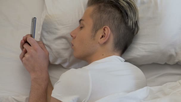Man die takenlijst op smartphone en vallen in slaap kamer, goede nacht bericht — Stockvideo