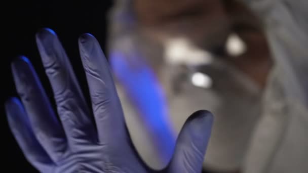 Lab scientist wearing exam gloves, reflection of test tubes in safety glasses — Stock Video